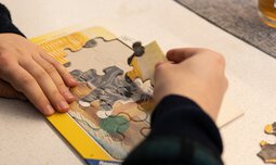 Eine Person versucht ein Puzzle zu lösen | © Caritas Werkstatt für Menschen mit Behinderung München